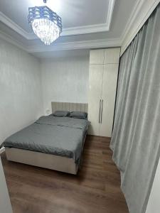 a bedroom with a bed and a chandelier at Бахт in Bishkek
