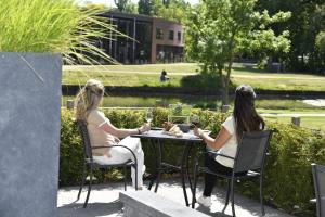 two women sitting at a table with glasses of wine at Hotel Wander in Wageningen
