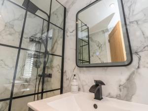 a bathroom with a shower and a sink and a mirror at Number 35 in Blackburn +15 photos