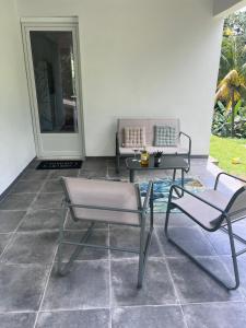 a patio with two chairs and a table and a couch at Résidence Atoumo in Rivière-Pilote