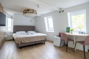 a bedroom with a bed and a table and chairs at Stadslogement Kingsize in Sneek