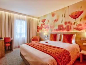 a hotel room with a large bed and a desk at Mercure Trouville Sur Mer in Trouville-sur-Mer +82 photos