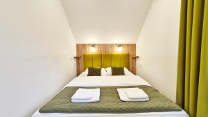 a bedroom with a bed with two towels on it at Urocza Kryjówka ze SPA in Lesko