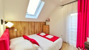 a bedroom with a bed with red sheets and a window at Urocza Kryjówka ze SPA in Lesko +24 photos
