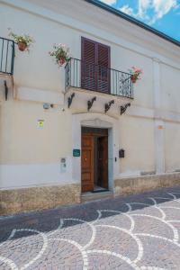 a white building with a door and a balcony at Hera Home B&B in Serra Pedace