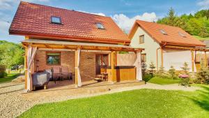 a house with a deck with a table and chairs at Urocza Kryjówka ze SPA in Lesko