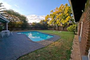 a swimming pool in the backyard of a house at Oolele BnB Newcastle in Newcastle +12 photos