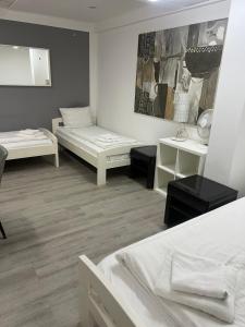 a room with two beds and two tables in it at Pension Passion Julie in Berlin +16 photos