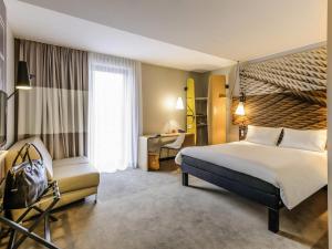 a hotel room with a large bed and a desk at Ibis Berlin Hauptbahnhof in Berlin +86 photos