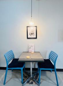a table with two chairs and a picture on the wall at JIYA Studio and Breakfast in Cebu City