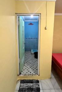 a bathroom with a door open to a bathroom with a shower at Motel Gemilang in Karimunjawa