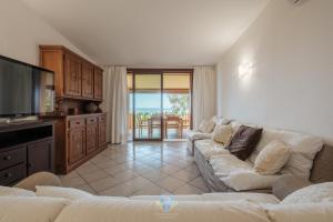 a living room with a couch and a tv at Villa Panorama Private Pool Costa Rei in Monte Nai