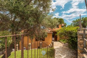 a house with a gate in front of a yard at Villa Panorama Private Pool Costa Rei in Monte Nai