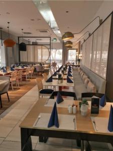 a dining room with long tables and chairs at Royal VIP in Kołobrzeg
