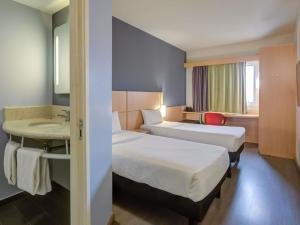 a hotel room with two beds and a sink at ibis Rio de Janeiro Nova America in Rio de Janeiro +127 photos