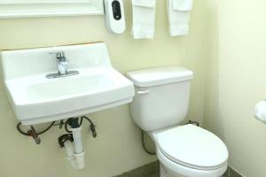 a white bathroom with a sink and a toilet at Williamston Inn NC Near Greenville US 64 in Williamston