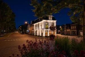 a white building on the side of a street at night at Stadslogement Kingsize in Sneek