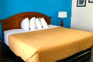 a bed with white pillows and a blue wall at Williamston Inn NC Near Greenville US 64 in Williamston