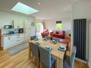 a kitchen and living room with a table and chairs at North Lodge in Forgandenny