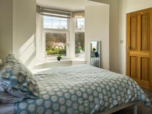 a bedroom with a bed and a window at North Lodge in Forgandenny