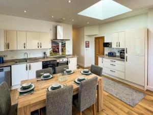 a kitchen with a wooden table and chairs at North Lodge in Forgandenny