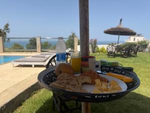 a tray of food on a table next to a pool at Villa Le Pacha Assilah in Asilah