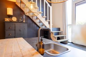 a kitchen with a sink and a wooden counter top at Thús yn Hantum Vakantiehuisje met hottub in Friesland in Hantum +28 photos
