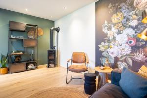 a living room with a painting of flowers on the wall at Thús yn Hantum Vakantiehuisje met hottub in Friesland in Hantum