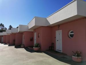 a row of red buildings with potted plants at Ribeirotel in Albergaria-a-Velha