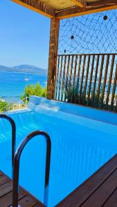 a swimming pool on a deck with a view of the ocean at Villa Tulivu in Paleros