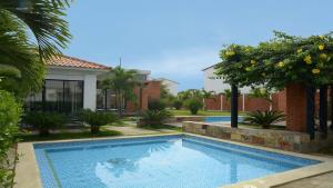 a swimming pool in front of a house at Sweet Home in San Guillermo