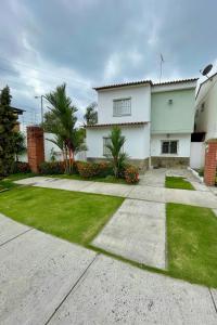 a large white house with a grass yard at Sweet Home in San Guillermo