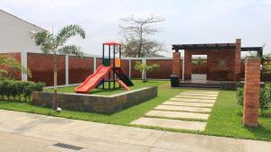 a playground with a red slide in a yard at Sweet Home in San Guillermo