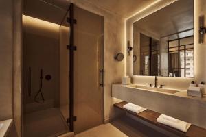 a bathroom with a shower and a sink and a mirror at Nobu Hotel Madrid in Madrid +55 photos