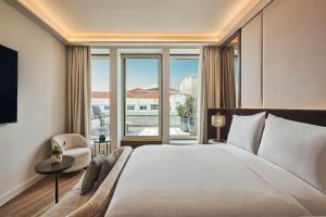 a bedroom with a large bed and a large window at Nobu Hotel Madrid in Madrid