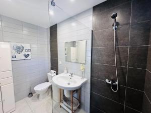 a bathroom with a toilet and a sink and a shower at Estúdio Villa Matilde e Joaquim in Porto da Cruz +15 photos