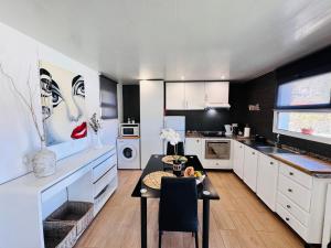 a kitchen with white cabinets and a table in it at Estúdio Villa Matilde e Joaquim in Porto da Cruz