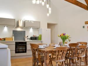 a kitchen with a wooden table and chairs at 'Ow Do - Uk11446 in Skipsea