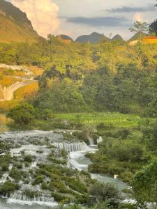 a river in the middle of a valley with trees at Thàng Khám homestay in Lũng Giên