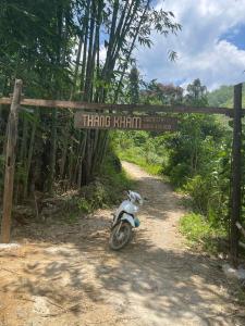 a motorcycle parked on a dirt road with a sign at Thàng Khám homestay in Lũng Giên