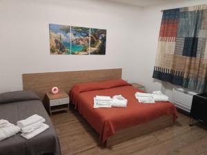 a bedroom with a red bed with towels on it at Da Tea in Olzai