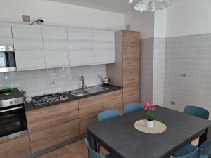 a kitchen with a sink and a table with chairs at Appartamento Felis in Molina di Ledro +7 photos