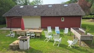 a table and chairs in front of a red building at Évasion nature en Normandie in La Patrie