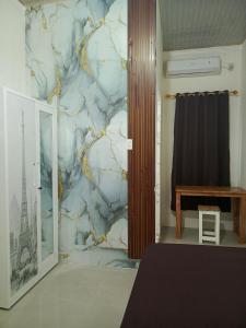 a living room with a marble wall at Kos Pramuka in Sunggal