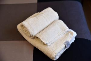 a stack of towels sitting on top of a bed at B&B Casale in Avellino +39 photos