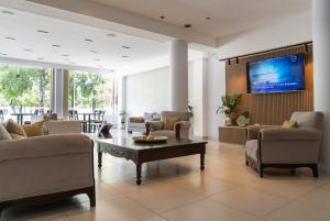 a living room with couches and a tv on a wall at Hotel Termal Emperatriz Termas de Río Hondo in Termas de Río Hondo