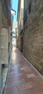 an alley with a stone building and a brick sidewalk at Tetka Guest House in Kotor