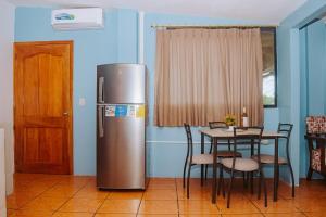 a kitchen with a refrigerator and a table with chairs at #5 Mini Suite, Cerca de Todo, 2-3 people - AC in Puerto Ayora