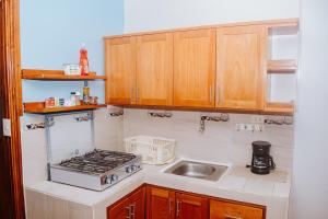 a kitchen with a sink and a stove at #5 Mini Suite, Cerca de Todo, 2-3 people - AC in Puerto Ayora +8 photos