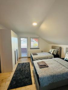 a bedroom with two beds and a couch in it at Apartman Feniks in Sjenica